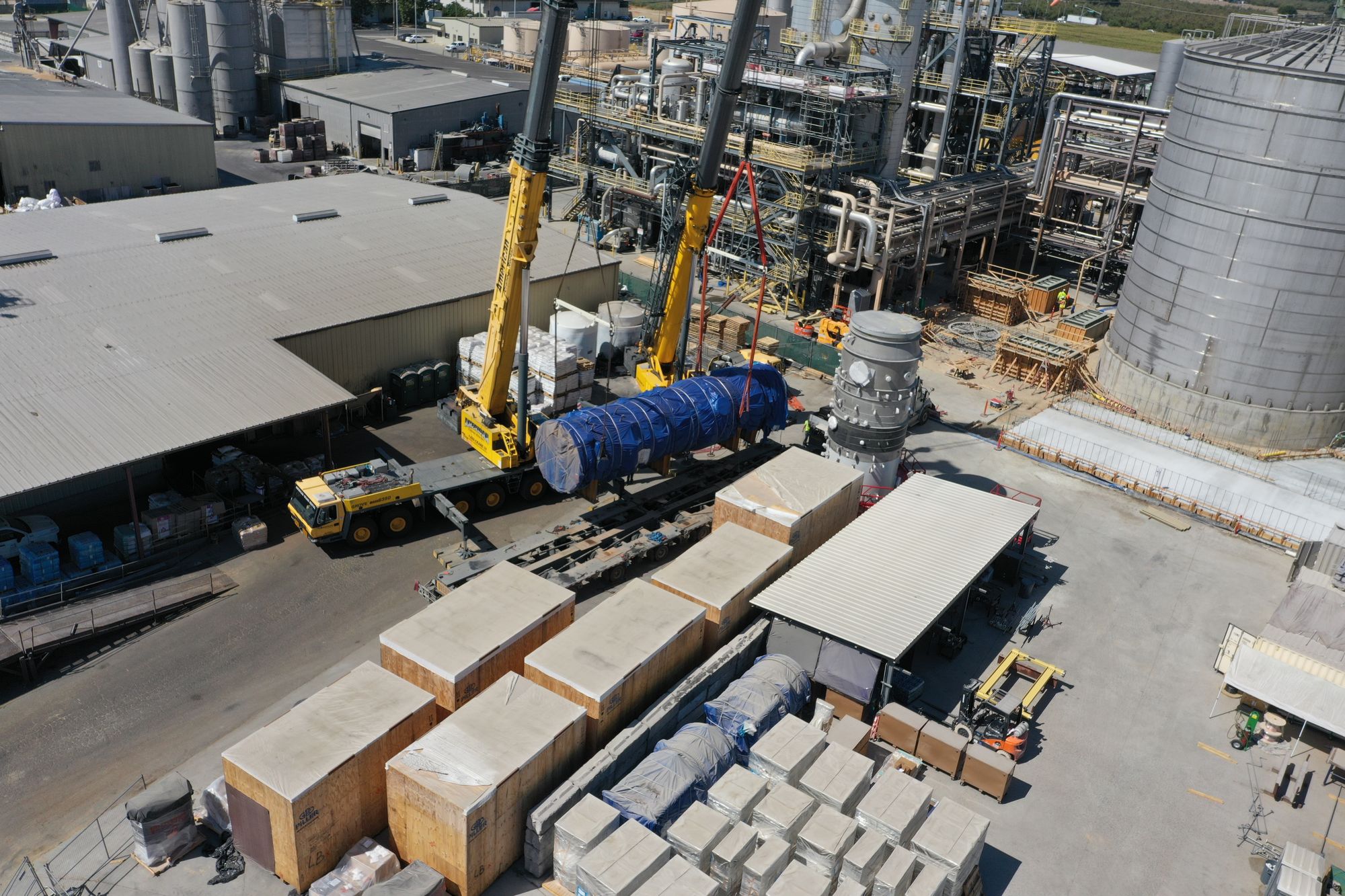 Two cranes performing a tandem lift of a 223,000-lb evaporator off a heavy haul trailer at a California industrial plant